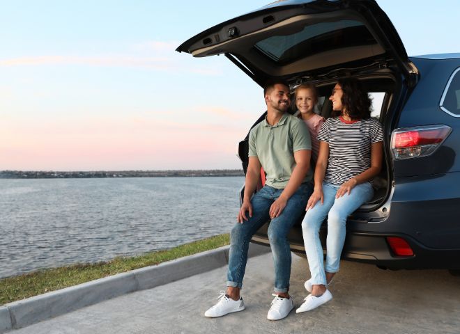 Family sitting on back of suv