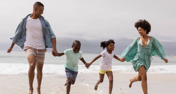 Family running together on the beach