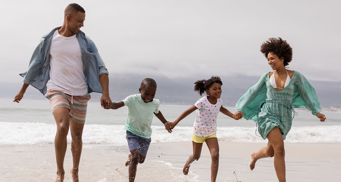 Family running together on the beach