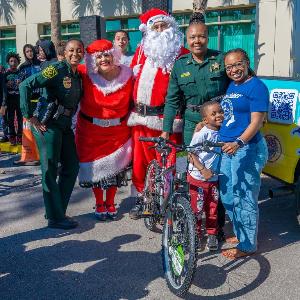 Santa and Mrs. Claus posing with officers and mother and son