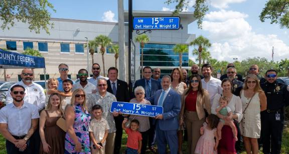 group of people standing in front of street sign