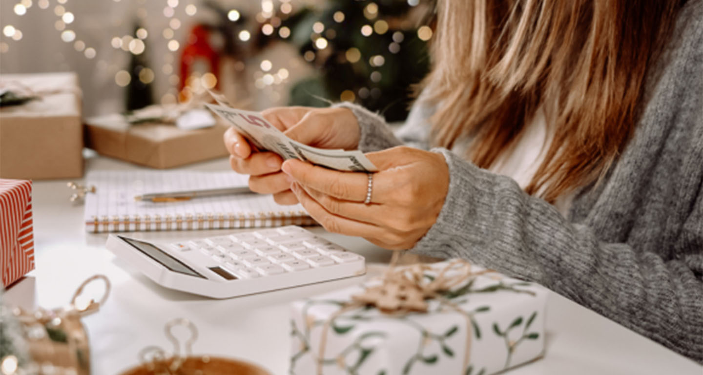 Woman holding money, planning holiday spending
