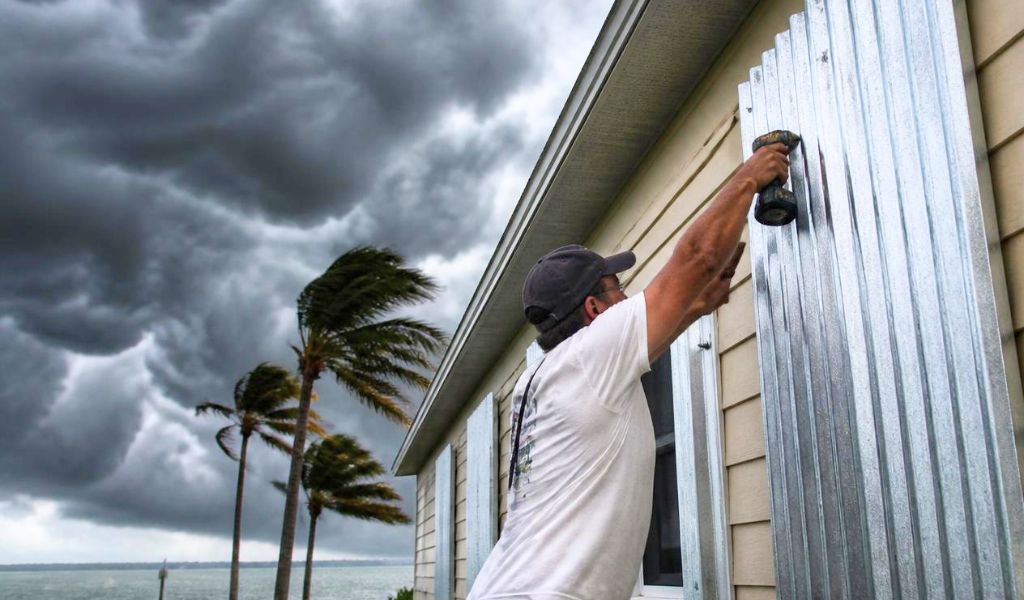 man putting up storm shutters