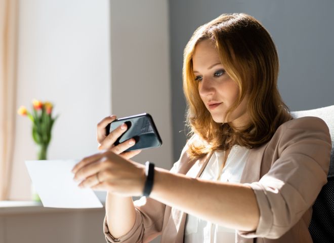 Woman using mobile phone for remote deposit